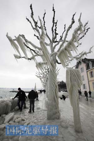 People walk on the ice covered pavement on the bank of Leman Lake in Versoix near Geneva